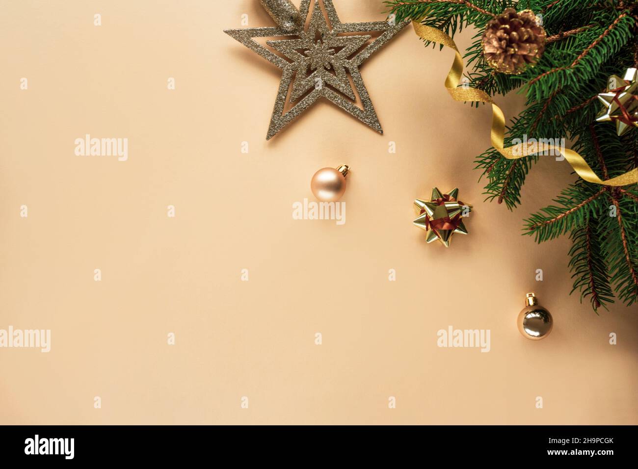 Composizione natalizia su sfondo giallo chiaro con rami di abete, giocattoli, stella e tinsel. Vista dall'alto, disposizione piatta, spazio di copia. Foto Stock