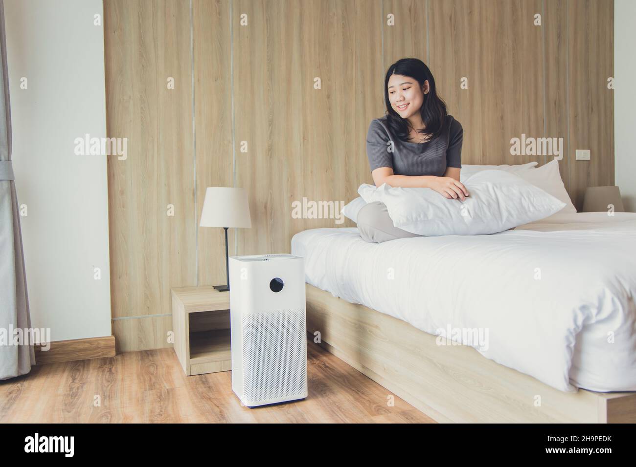 Personale sanitario che utilizza il purificatore d'aria o il condizionatore d'aria per aria pulita in camera da letto Foto Stock