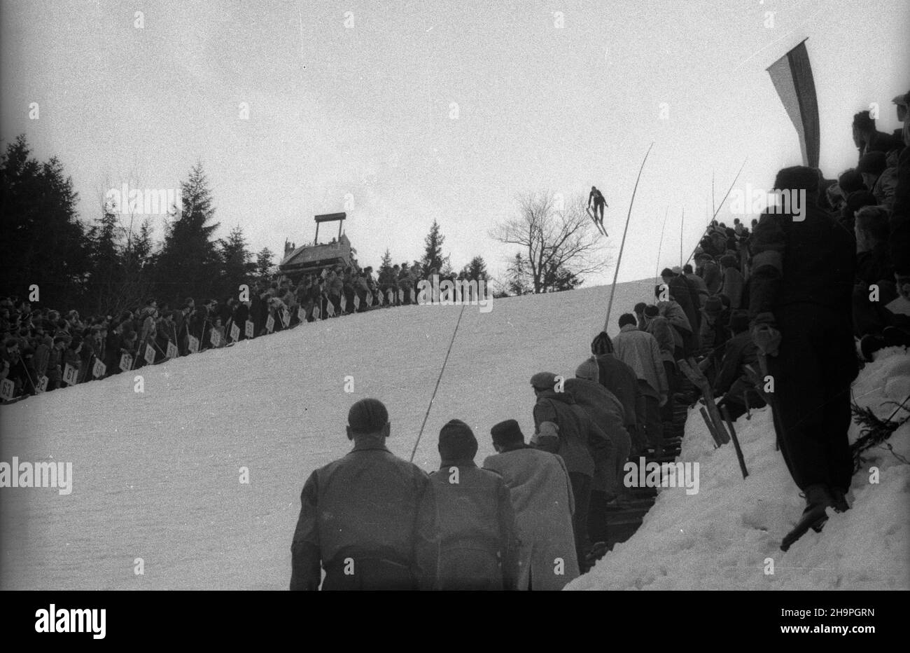 Zakopane, 1949-02-25. W Miêdzynarodowych Zawodach Narciarskich o Puchar Tatr wziê³o udzia³ przesz³o 250 zawodników i zawodniczek reprezentuj¹cych szeœæ pañstw: Czechos³owacjê, Wêgry, Rumuniê Bu³gariê, Finlandiê i Polskê. Otwarty konkurs skoków obejrza³o na stadionie PZN (Polski Zwi¹zek Narciarski) pod Krokwi¹ dwadzieœcia tysiêcy widzów. uu PAP Zakopane, 25 febbraio 1949. Il concorso internazionale di sci della Coppa Tatra ha riunito oltre 250 concorrenti provenienti da 6 paesi: Cecoslovacchia, Ungheria, Romania, Bulgaria, Finlandia e Polonia. Un evento di salto con gli sci è stato osservato da 20.000 persone Foto Stock