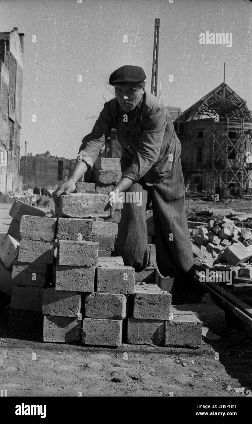 Warszawa, 1949-03. Budowa Trasy W-Z - ci¹gu komunikacyjnego Wschód-Zachód. NZ. Budowa jezdni i torowiska tramwajowego na T³omackiem (róg ulicy Bielañskiej i T³omackiej) - prace brukarskie; w g³êbi XVIII-wieczny pa³ac Przebendowskich (Radziwi³³ów) przy ulicy Bielañskiej 14, odbudowywany po zniszczeniach wojennych wed³ug projektu a Brunzdaryego Dok³adny dzieñ zdaryskij Zustanskij. Varsavia, marzo 1949. La costruzione della W-Z Route (linea di comunicazione est-ovest). Nella foto: La costruzione di una strada e di una linea di tram su Tlomackie (angolo di Bielanska Foto Stock