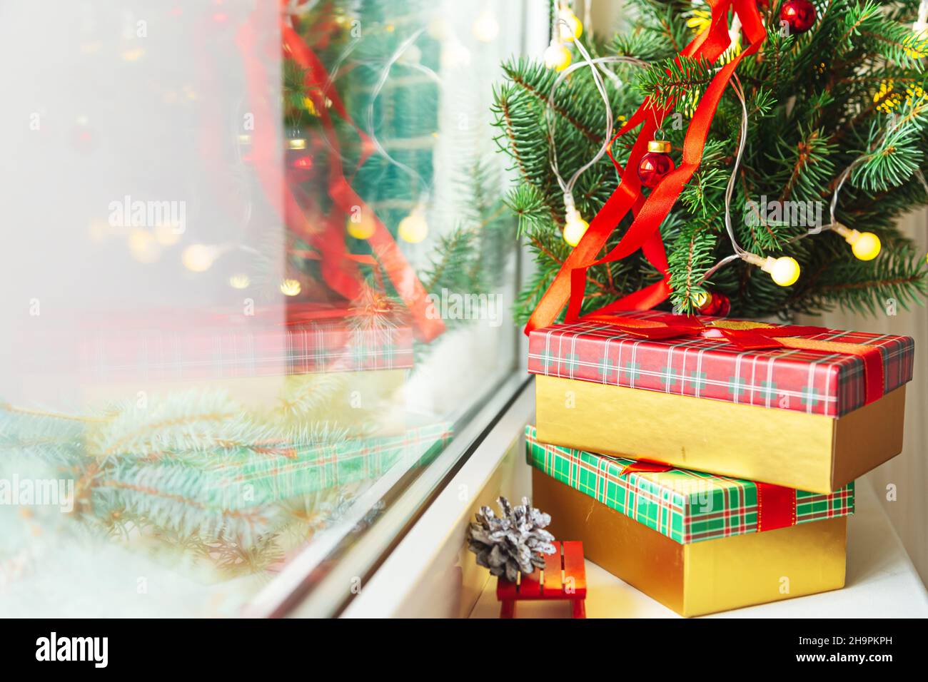 Decorazioni di Natale e Capodanno. Scatole regalo, rami di abete, ghirlone sul davanzale. Natale accogliente. Foto Stock