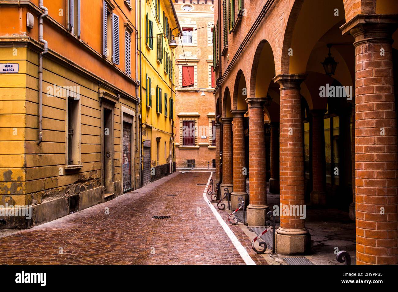 Bella strada italiana, edifici colorati con portici. Bologna, Italia. Foto Stock