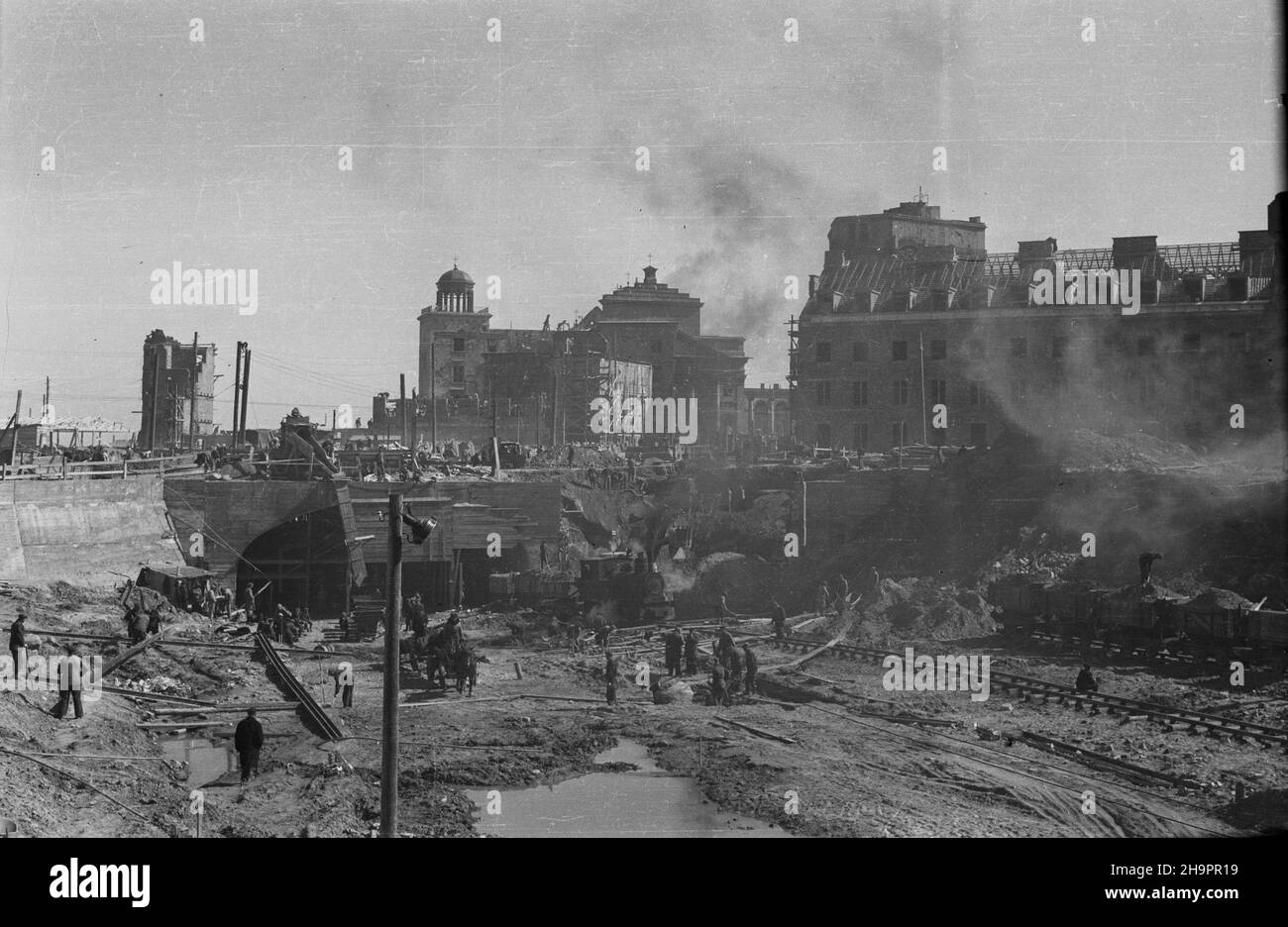 Warszawa, 1949-03. Budowa Trasy W-Z (Trasa Wschód-Zachód). NZ. Prace ziemne i dogowe na wschodnim odcinku Trasy W-Z (wlot jezdni trasy do tunelu od strony ulicy Miodowej); w g³êbi gmach odbudowywanego Pa³acu Biskupów Krakowskich (P) oraz koœció³ pw. œw. Anny wraz z dzwonnic¹ (C), widok z nowo budowanej ulicy Kapucyñskiej. mta PAP Dok³adny dzieñ wydarzenia nieustalony. Varsavia, marzo 1949. La costruzione del percorso W-Z (Est-Ovest). Nella foto: Lavori di terra e costruzione di strade sul lato orientale del percorso W-Z (l'ingresso al tunnel da Miodowa Street); sullo sfondo il Cracow Foto Stock