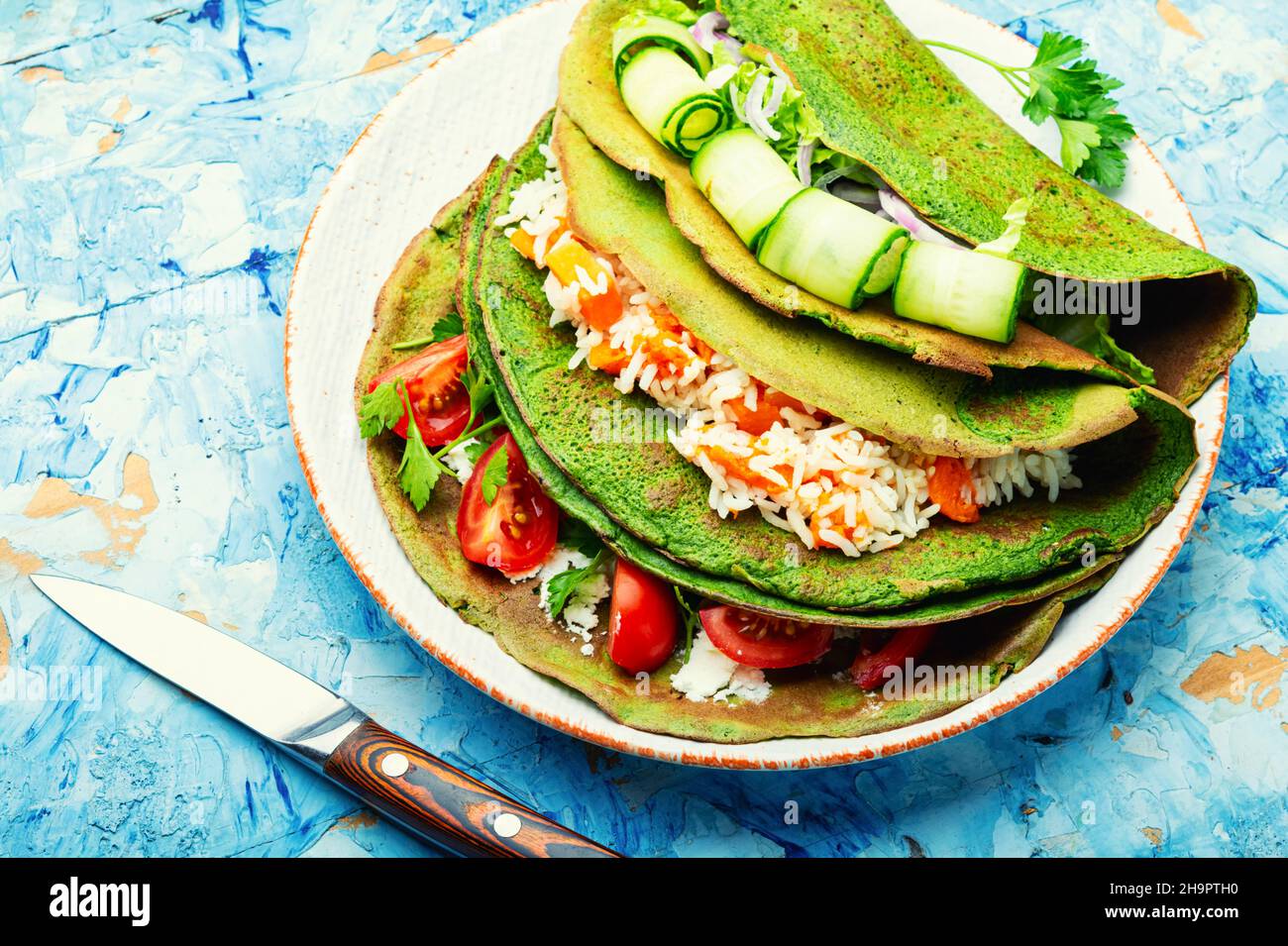 Frittelle di spinaci verdi farcite di riso e verdure. Foto Stock