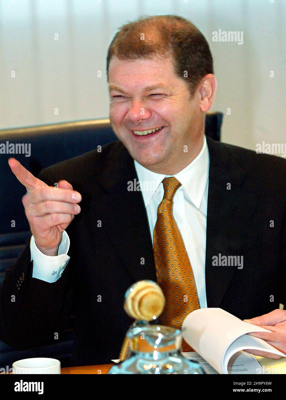 Lachend sitzt der Generalsekretär der SPD, OLAF Scholz, am 24.11.2003 zu Beginn der Präsidiumssitzung a Berlin am Konferenztisch. Scholz will bis mai 2004 Hamburger SPD-Landesvorsitzender bleiben. Klar sei, dass er dann nicht zu einer erneuten Kandatur antreten werde. Wann ein Nachfolger bestimmt wird, sei unklar. Scholz hatte bei seiner Wiederwahl als Generalsekretär auf dem Bochumer Bundesparteitag mit 52, 6 Prozent ein schlechtes Ergebnis bekommen und war daraufhin auch in der Hamburger SPD wegen seiner Doppelbelastung in die Kritik geraten. Foto Stock