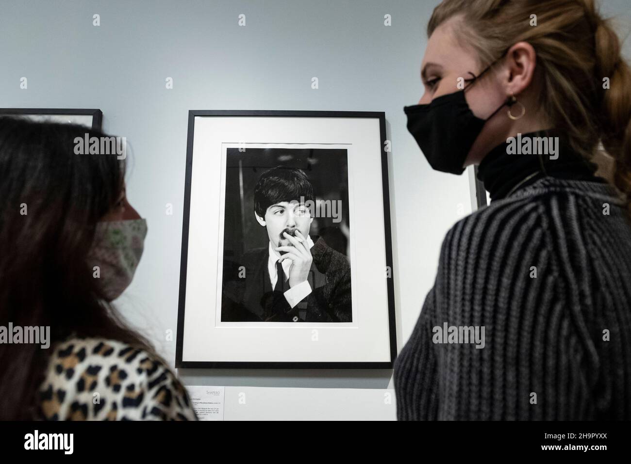 Londra, Regno Unito. 8 dicembre 2021. I membri dello staff vedano una foto di Paul McCartney in anteprima di una mostra di fotografie perdute dei Beatles di Lord Thynne, figlio della marchessa di Bath del 6th. La mostra, con immagini candide della band nella primavera del 1964 sul set del loro primo film A Hard Day’s Night, si trova alla Shapero Modern Gallery di Mayfair fino al 16 gennaio 2022. Credit: Stephen Chung / Alamy Live News Foto Stock