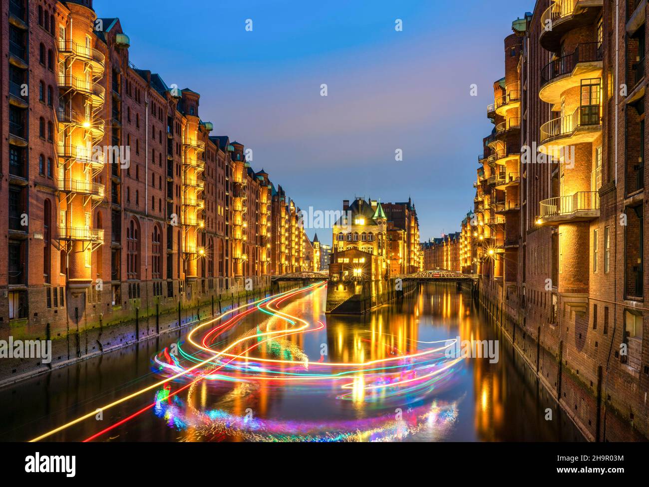 Foto notturna del castello ormeggiato e una nave da escursione con luci fairy nella Speicherstadt, Amburgo, Germania Foto Stock