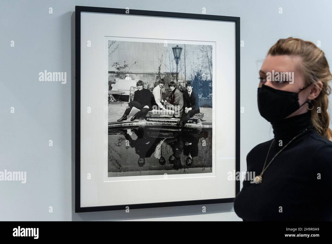 Londra, Regno Unito. 8 dicembre 2021. Un membro dello staff con una foto della band in anteprima di una mostra di fotografie perse dei Beatles di Lord Thynne, figlio della marchessa di Bath del 6th. La mostra, con immagini candide della band nella primavera del 1964 sul set del loro primo film A Hard Day’s Night, si trova alla Shapero Modern Gallery di Mayfair fino al 16 gennaio 2022. Credit: Stephen Chung / Alamy Live News Foto Stock