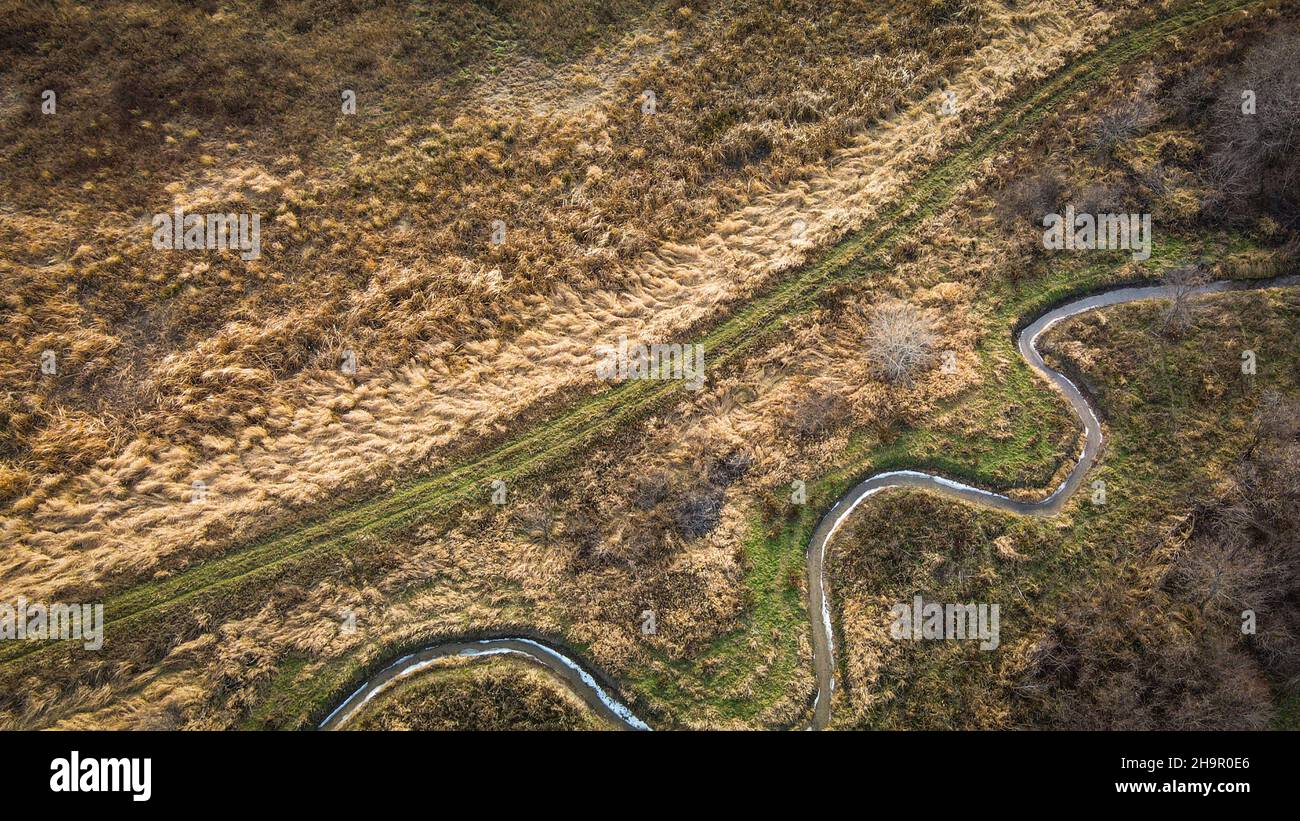 Paesaggi rurali con ruscello curvo con sentieri natura Foto Stock
