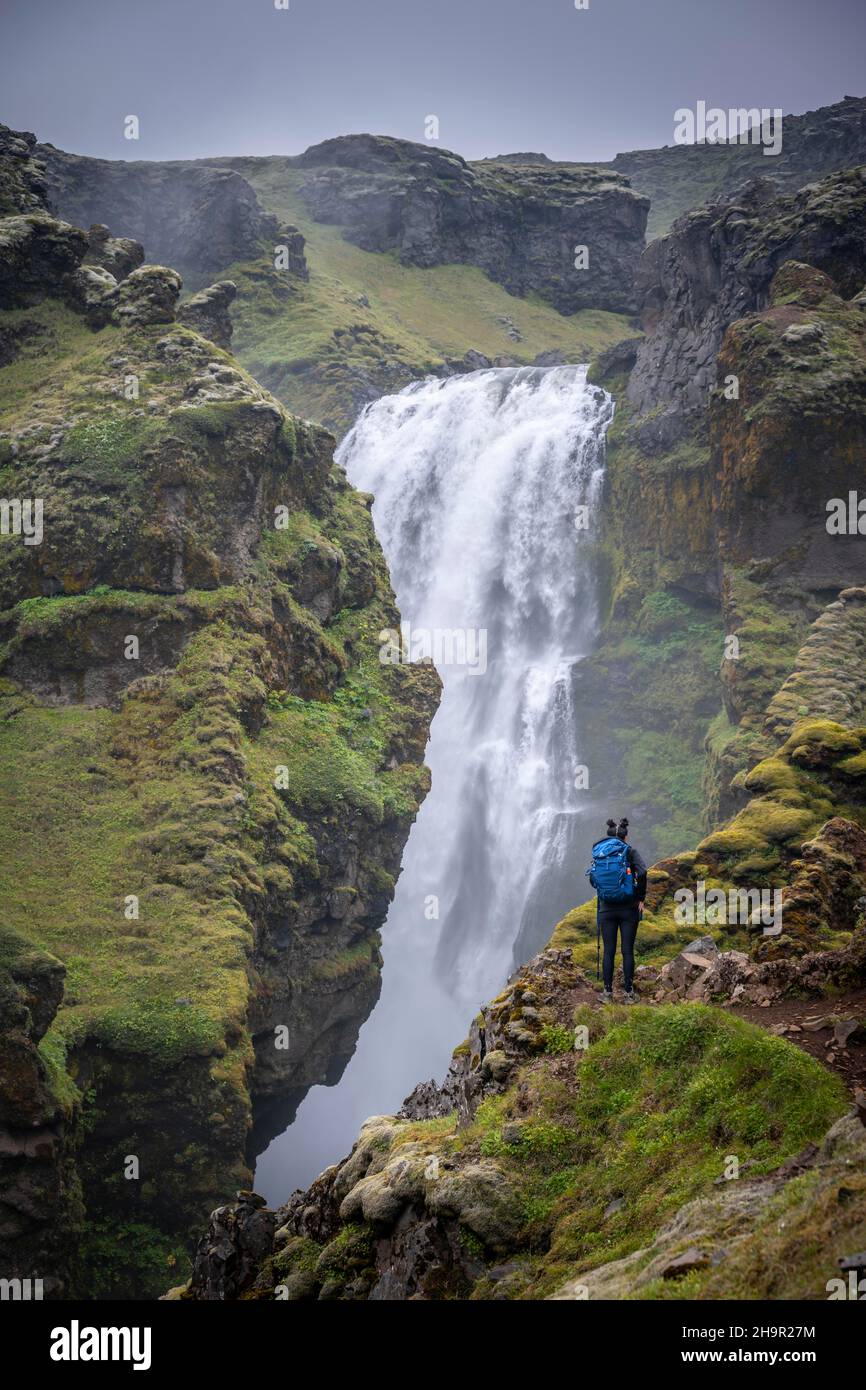 Escursionisti a una cascata in una gola, paesaggio a Fimmvoerouhals sentiero escursionistico, Islanda del Sud, Islanda Foto Stock