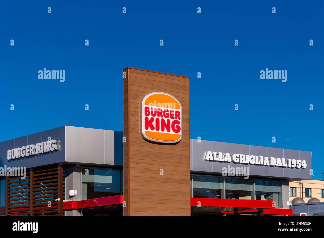 Moncalieri, Torino, Italia - 6 dicembre 2021: Cartello con nuovo logo del Burger King Restaurant su cielo blu con nuvole in via fortunato Postiglione i Foto Stock