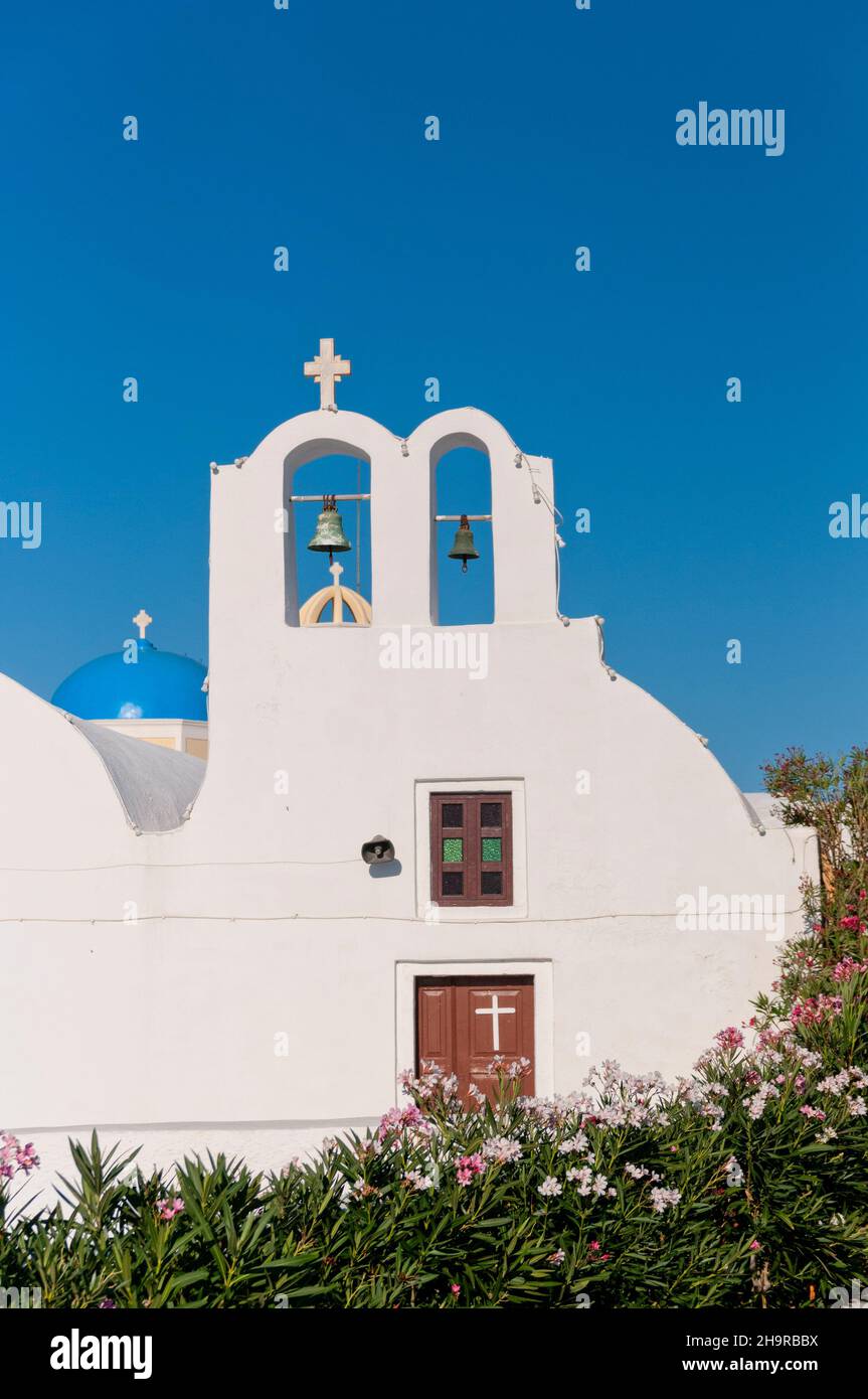 La facciata anteriore di una chiesa dalle pareti bianche contro il cielo blu di Santorini, in Grecia. Foto Stock