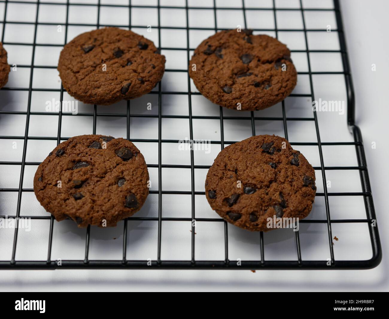 biscotti con scaglie di cioccolato su griglia di raffreddamento con sfondo bianco. Buongiorno. Foto Stock