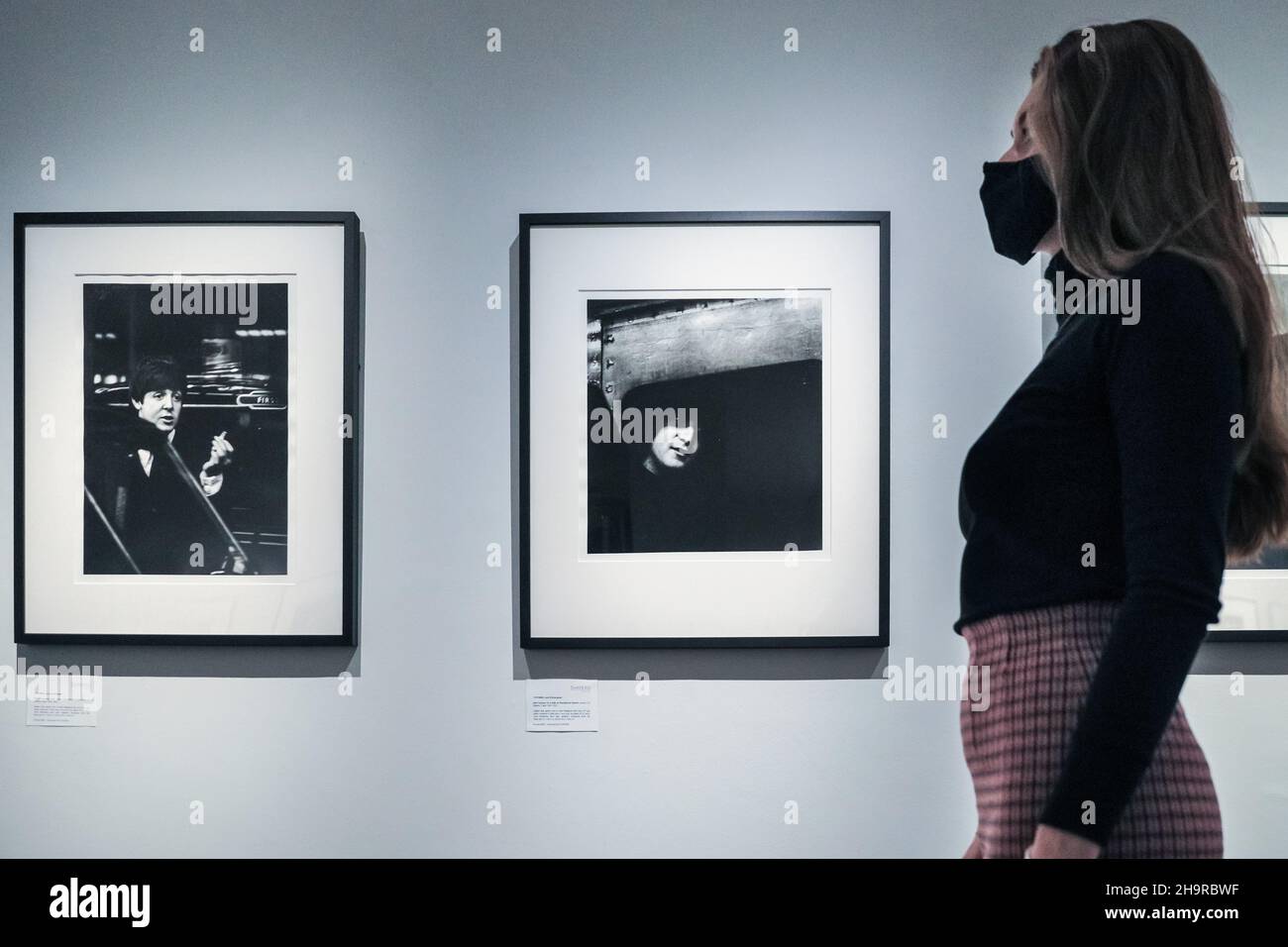 Londra, Regno Unito. 8th Dic 2021. Un membro dello staff guarda le immagini. Riscoperta in documenti di famiglia dopo 57 anni e sviluppata da negativi, le fotografie perse dei Beatles sono viste in una rara mostra alla Galleria moderna di Shapero. Il fotografo, Lord Thynne, ha catturato candidi colpi della band nella primavera del 1964, sul set del loro primo film A Hard Day's Night. I negativi sono rimasti insviluppati per cinquantasette anni. Credit: Imagplotter/Alamy Live News Foto Stock