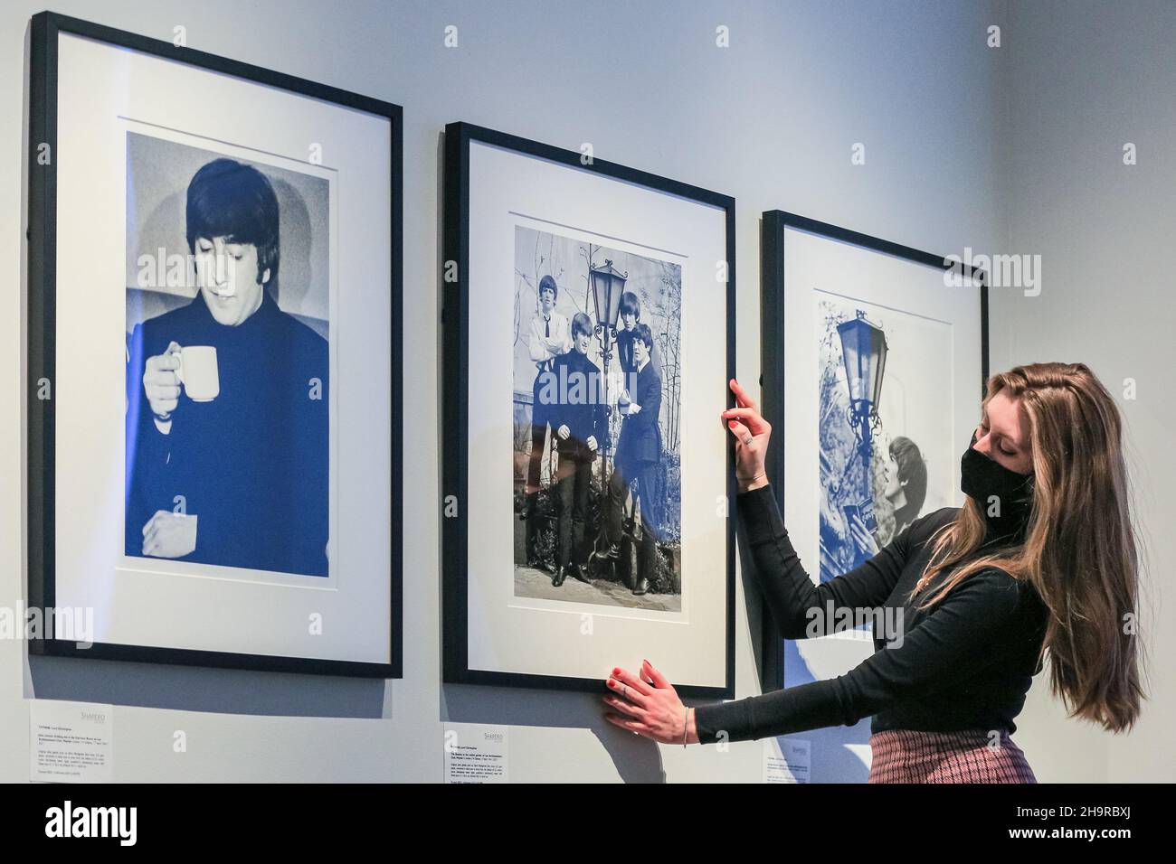 Londra, Regno Unito. 8th Dic 2021. Un membro dello staff guarda le foto, qui una rara foto di gruppo. Riscoperta in documenti di famiglia dopo 57 anni e sviluppata da negativi, le fotografie perse dei Beatles sono viste in una rara mostra alla Galleria moderna di Shapero. Il fotografo, Lord Thynne, ha catturato candidi colpi della band nella primavera del 1964, sul set del loro primo film A Hard Day's Night. I negativi sono rimasti insviluppati per cinquantasette anni. Credit: Imagplotter/Alamy Live News Foto Stock