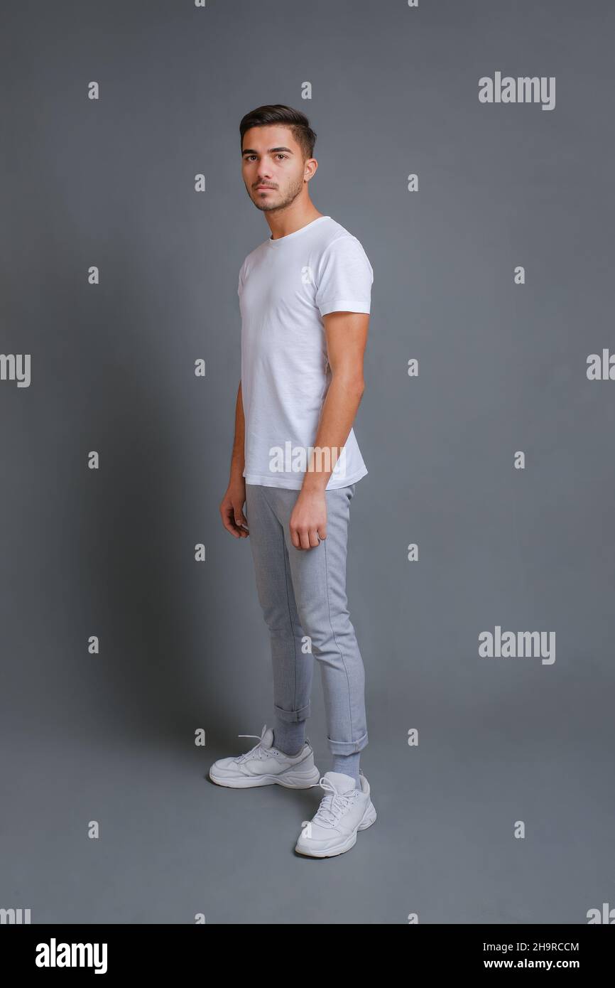 Ritratto a tutta lunghezza di un giovane uomo sicuro in t-shirt bianca Foto Stock