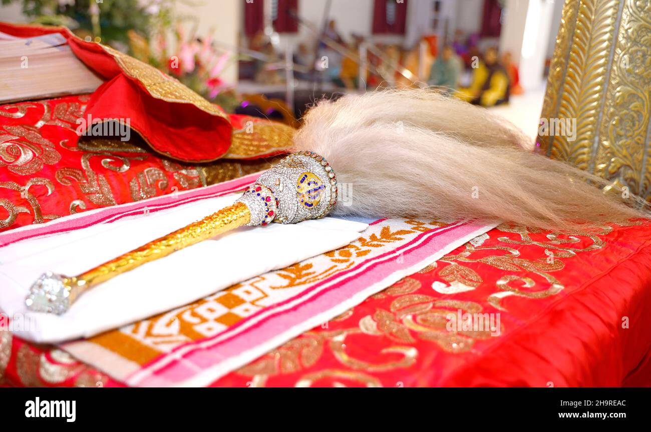 Delhi, India - Febbraio, 2020: Fan per adorare Guru Granth Sahib all'interno di un Gurudwara con impugnatura d'oro e simbolo sikh Foto Stock