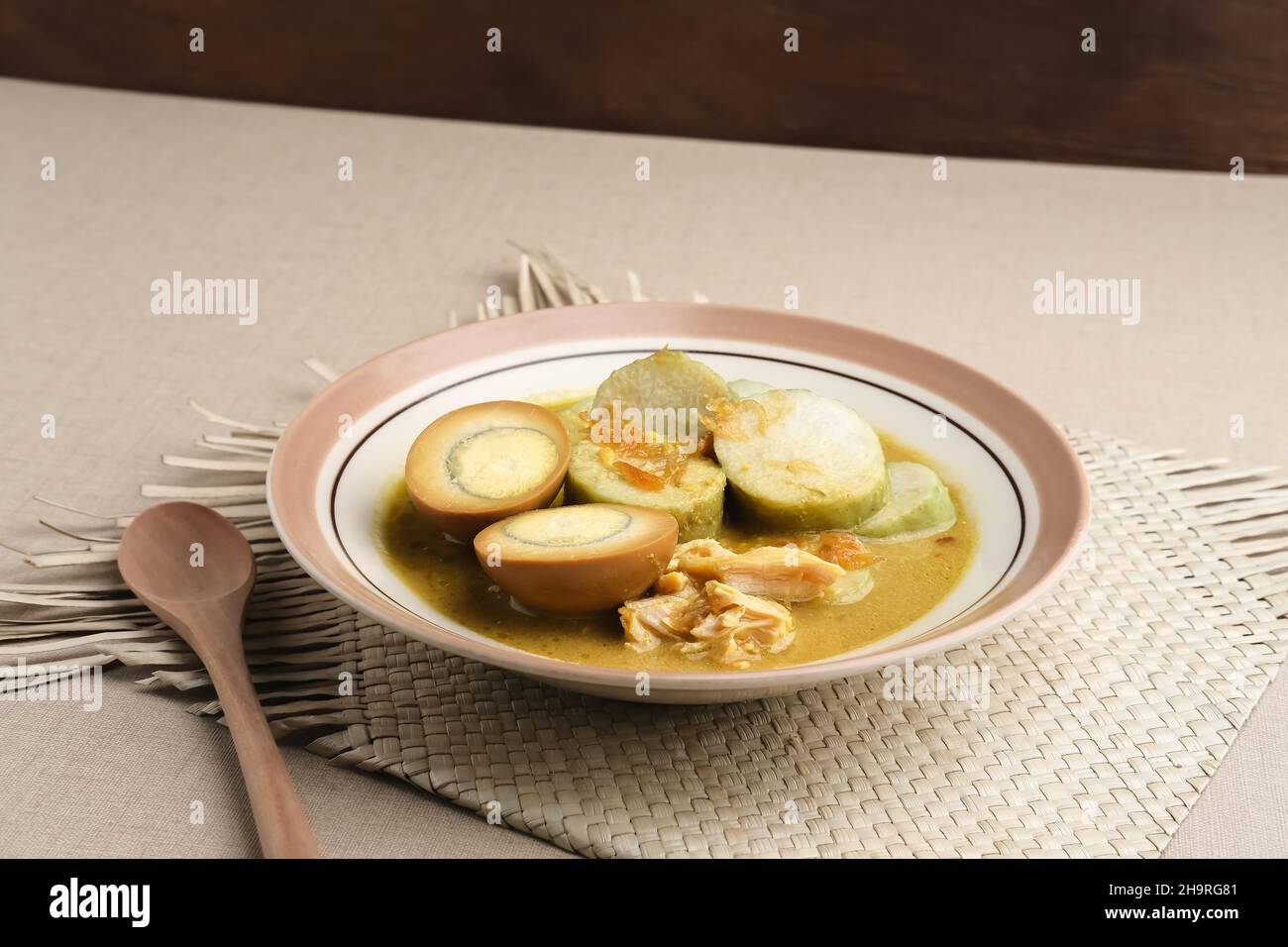 Lontong Opor, colazione tradizionale indonesiana o menu Eid. Opor a base di pollo cotto con latte di cocco e spezie. Foto Stock