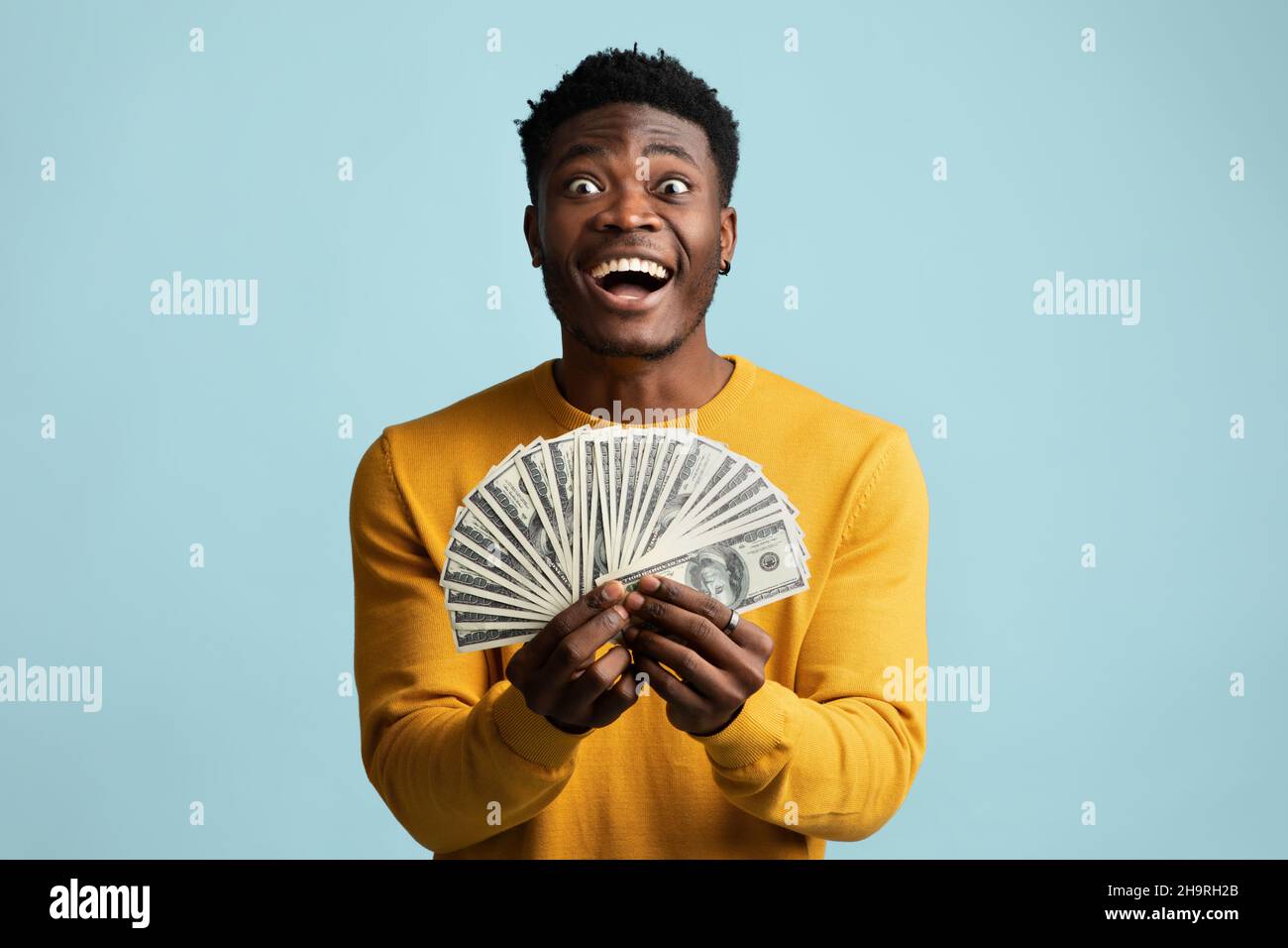 Fortunato ragazzo africano americano che tiene mazzo di soldi Foto Stock