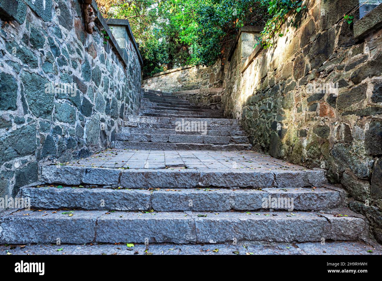 Una strada stretta con scalini e muri in pietra Foto Stock