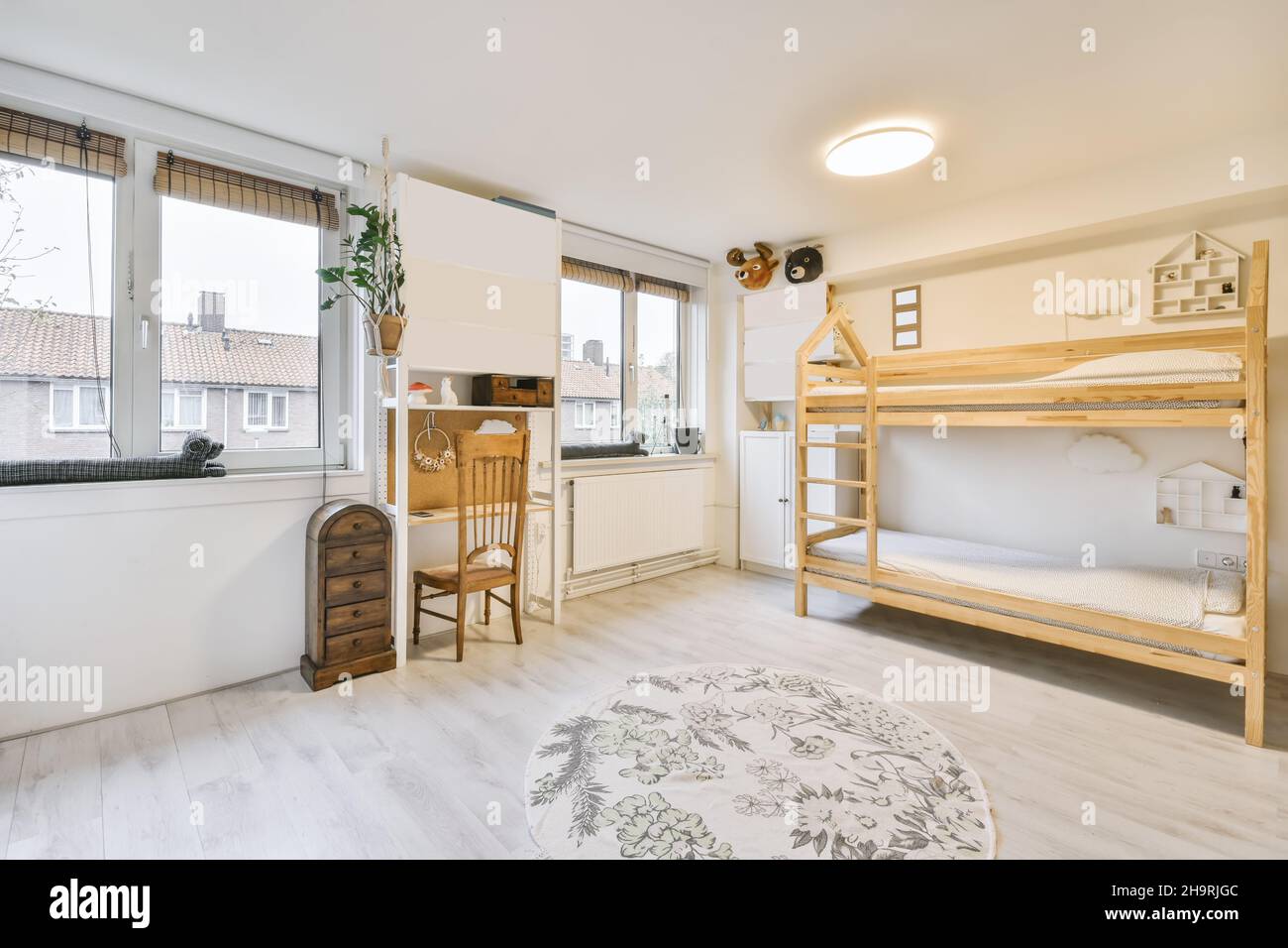 Accogliente camera per bambini con un letto in legno a due piani e un tappeto rotondo Foto Stock
