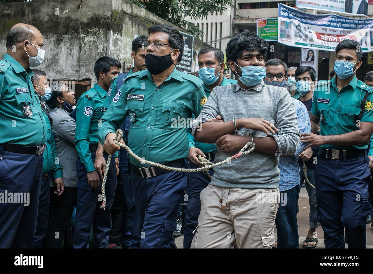 Dhaka, Bangladesh. 08th Dic 2021. Gli ufficiali di polizia scortano fuori dai tribunali uno dei 20 studenti universitari condannati dopo la loro condanna a morte per il brutale assassinio del 2019 di un giovane che ha criticato il governo sui social media a Dhaka. Mercoledì un tribunale di Dhaka ha condannato a morte 20 giovani uomini e cinque a vivere in carcere per aver ucciso un 21 anni di nome Abrar Fahad, studente di ingegneria elettrica ed elettronica presso la Bangladesh University of Engineering and Technology (Buet) nell'ottobre 2019. (Foto di Sazzad Hossain/SOPA Images/Sipa USA) Credit: Sipa USA/Alamy Live News Foto Stock