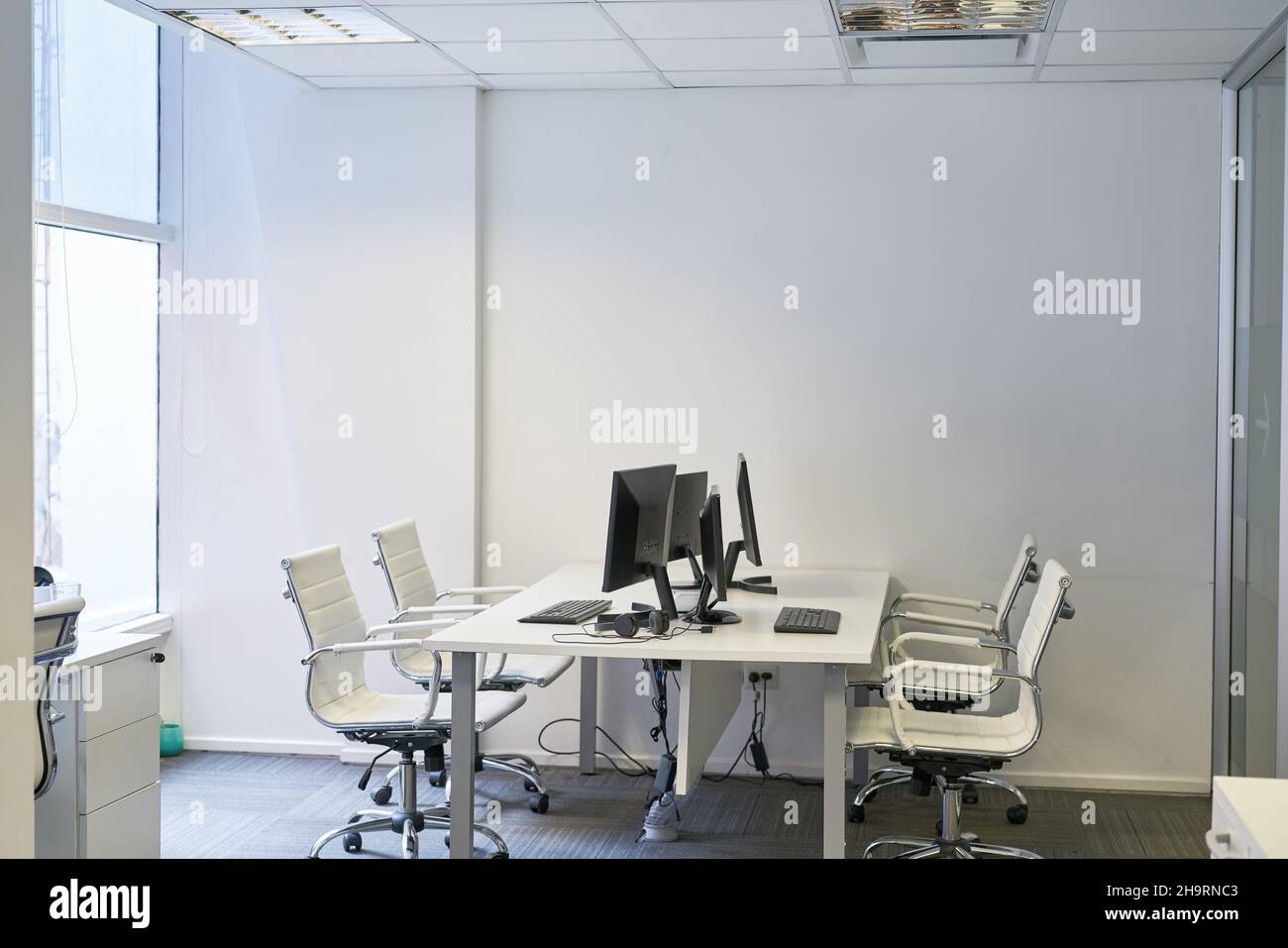 Un ufficio che lavora con una scrivania e molte workstation per computer Foto Stock