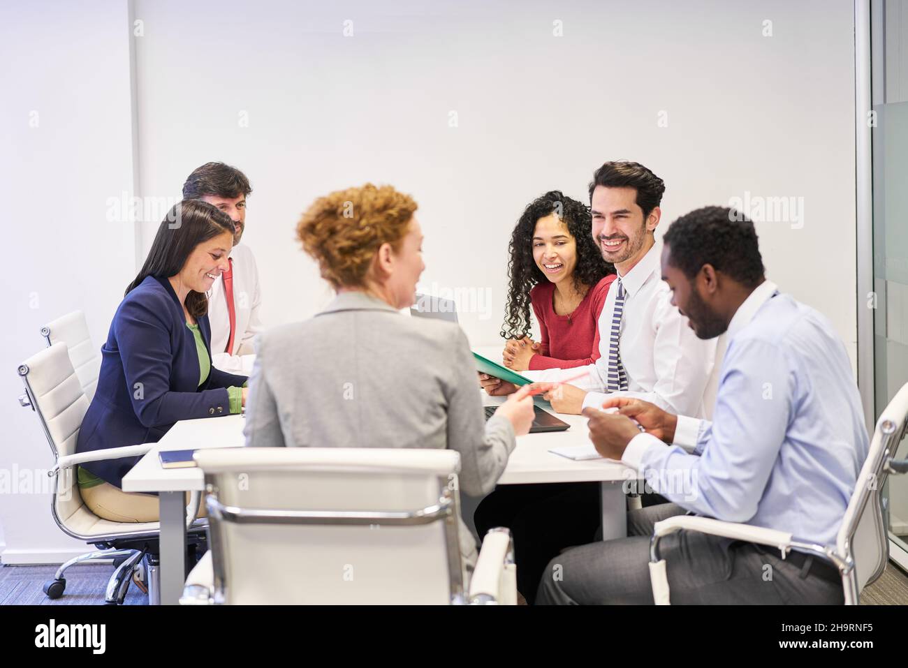 Team di start-up multiculturale al tavolo della conferenza in una riunione strategica Foto Stock