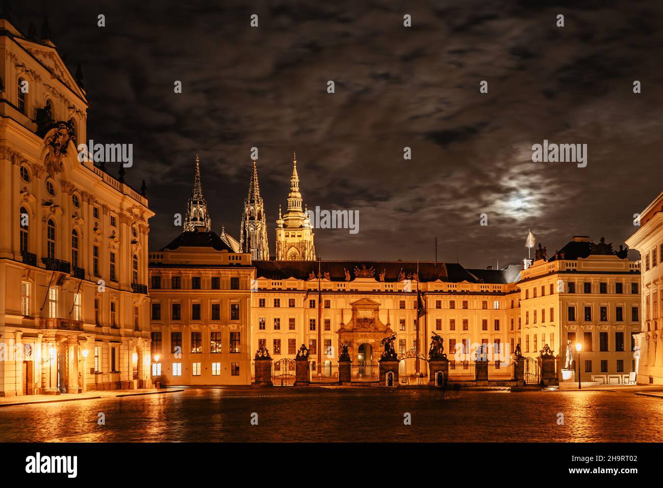 Porta principale del Castello di Praga con statue di notte, illuminata Cattedrale di San Vito sullo sfondo. Sito UNESCO, famosa destinazione di viaggio. Città serale Foto Stock