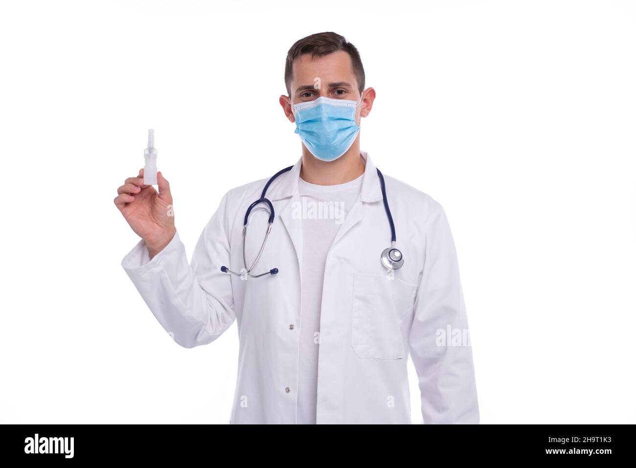 Spray nasale di tenuta medico isolato. Uomo medico con spray nasale in mani indossare maschera medica Foto Stock