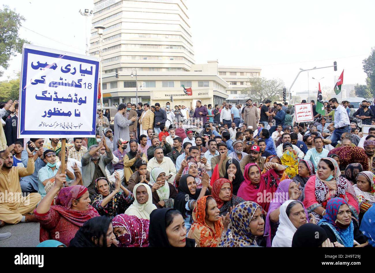 I residenti di Lyari bloccano la strada mentre stanno tenendo la manifestazione di protesta contro il prolong sui-gas di carico spargimento nella loro zona, organizzato da Peoples Party (PPP), tenuto vicino Shaheen complesso edificio a Karachi il mercoledì 08 dicembre 2021. Foto Stock