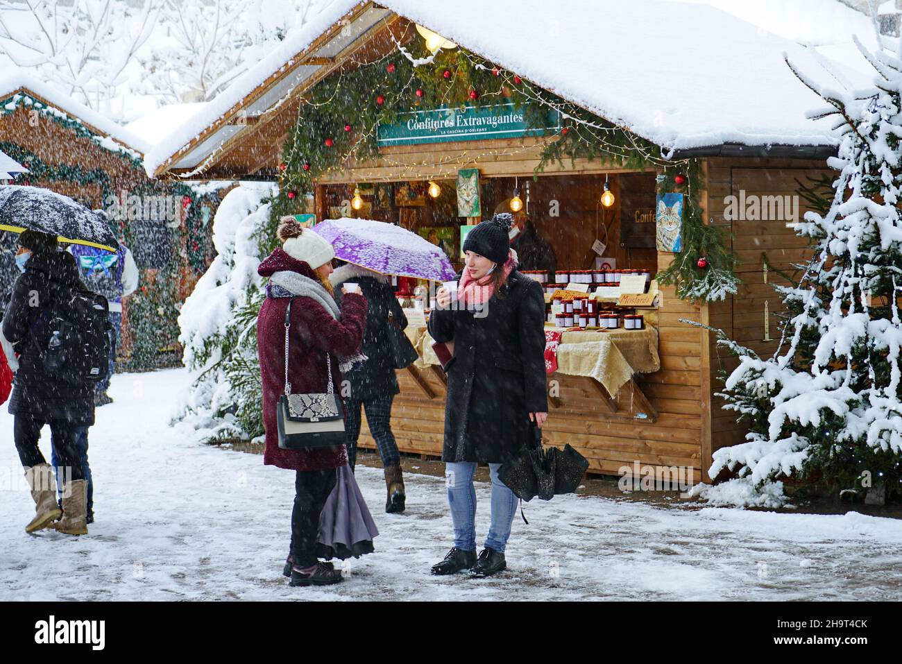 Tradizionale mercatino di Natale sotto nevicate pesanti. Aosta, Italia - Dicembre 2021 Foto Stock