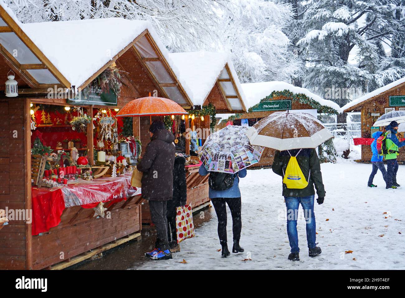 Tradizionale mercatino di Natale sotto nevicate pesanti. Aosta, Italia - Dicembre 2021 Foto Stock
