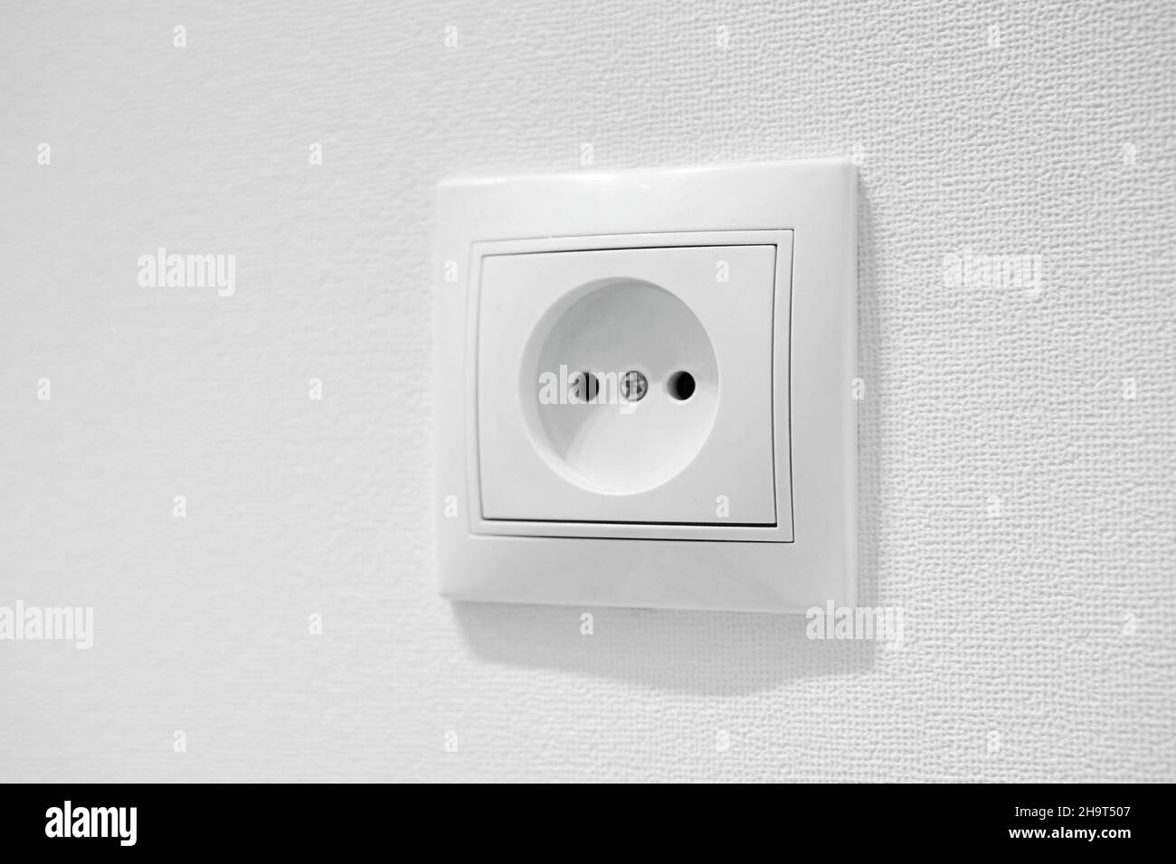 Comune presa a muro CA in plastica a basso costo. Connettore femmina circolare a cavità tedesco con due fori rotondi per connettori maschio Euro a 2 pin tipo C, e e F. senza messa a terra Foto Stock