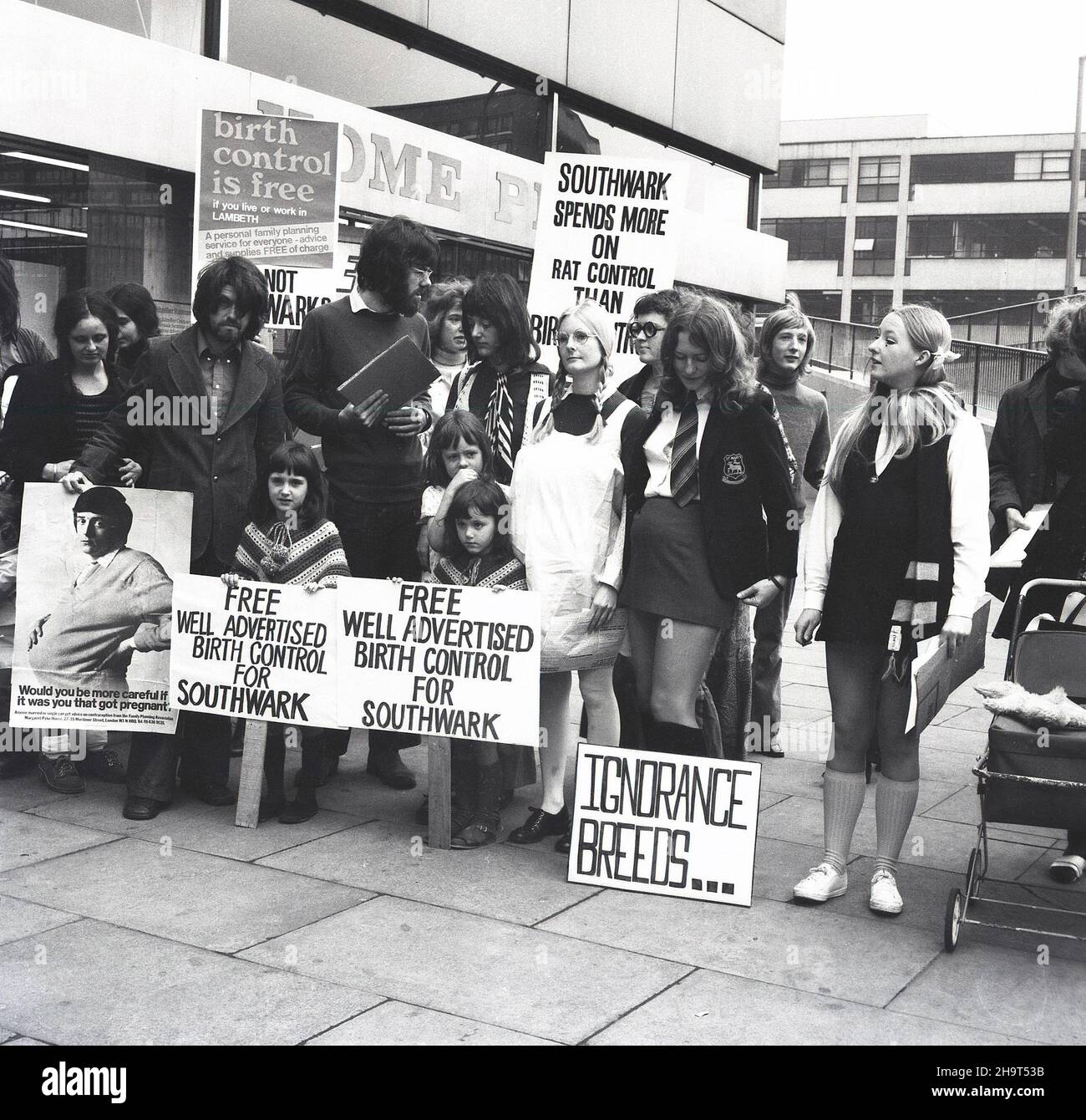 1970s, storico, gruppo di persone, principalmente donne, con striscioni e cartelli, facendo una protesta fuori da un centro commerciale circa il fallimento del Southwark Consiglio di offrire libero controllo delle nascite e contraccezione. Un poster dice: "Outhwark spende più sul controllo del ratto che sul controllo delle nascite". La capacità delle giovani donne non sposate di accedere alla contraccezione e prevenire i premessi indesiderati è rimasta limitata fino alla fine del 1970s. Foto Stock