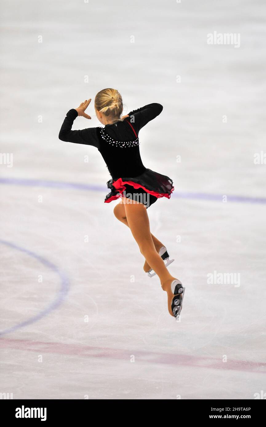 Piccola ragazza figura skater pattinaggio su ghiaccio al coperto Foto Stock