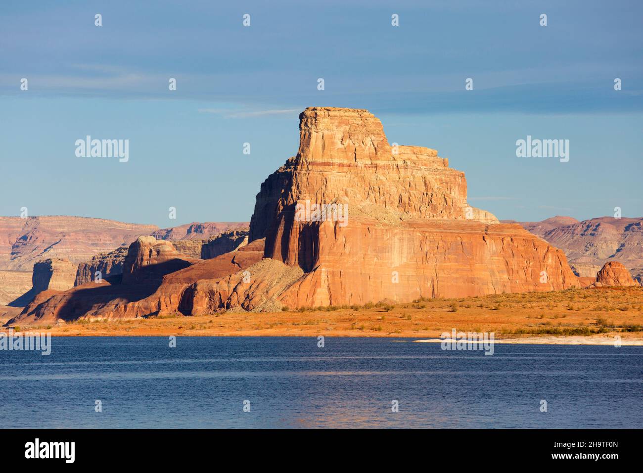 Glen Canyon National Recreation Area, Utah, USA. Le alte scogliere di arenaria di Gunsight Butte torreggiano sopra Padre Bay, il Lago Powell, la mattina presto. Foto Stock