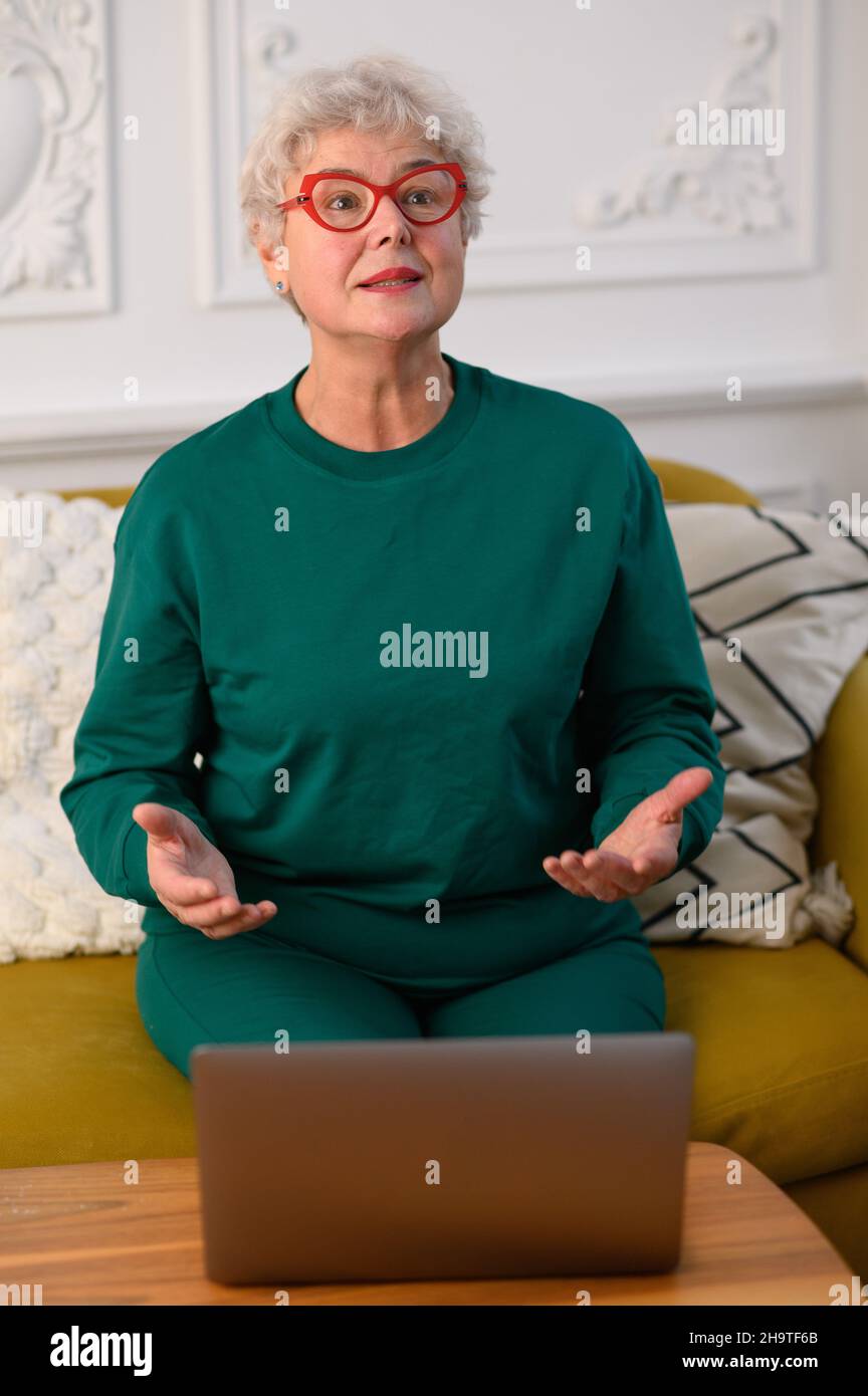 nonna sta parlando in videoconferenza con la sua famiglia. Mezzi moderni di comunicazione Foto Stock