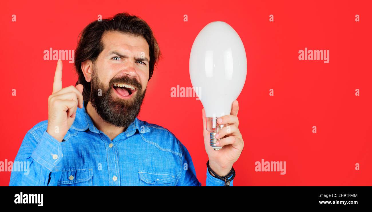 Buona idea. L'uomo barbuto con la lampadina mostra un dito verso l'alto. Nascita di idee. Creatività e brainstorming. Spazio di copia. Foto Stock