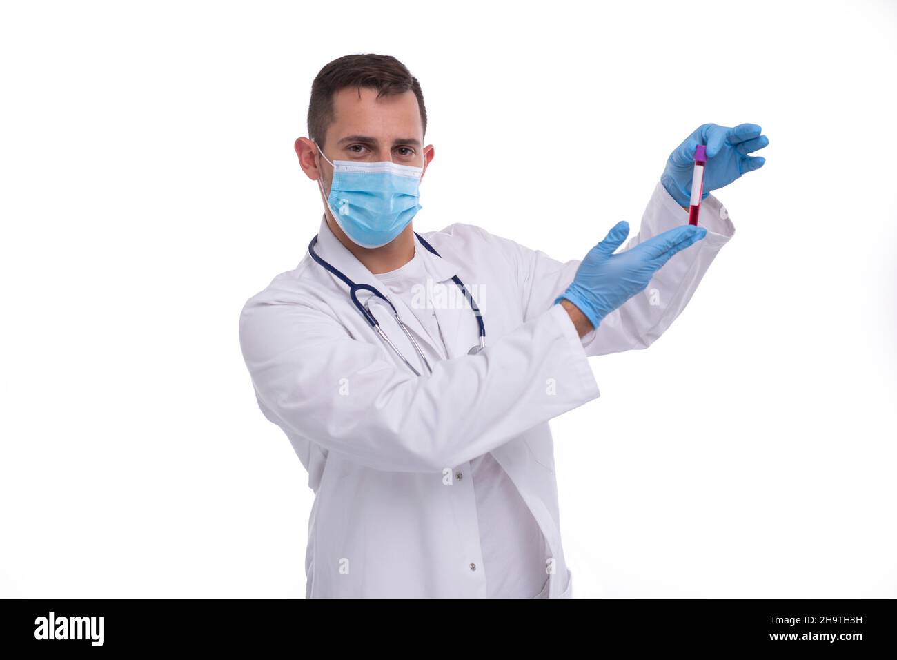 Maschio medico controllo analisi del sangue indossare maschera medica e guanti. Man Doctor che esamina la provetta del sangue isolata. Medicina, Scienza, concetto di vita sana Foto Stock