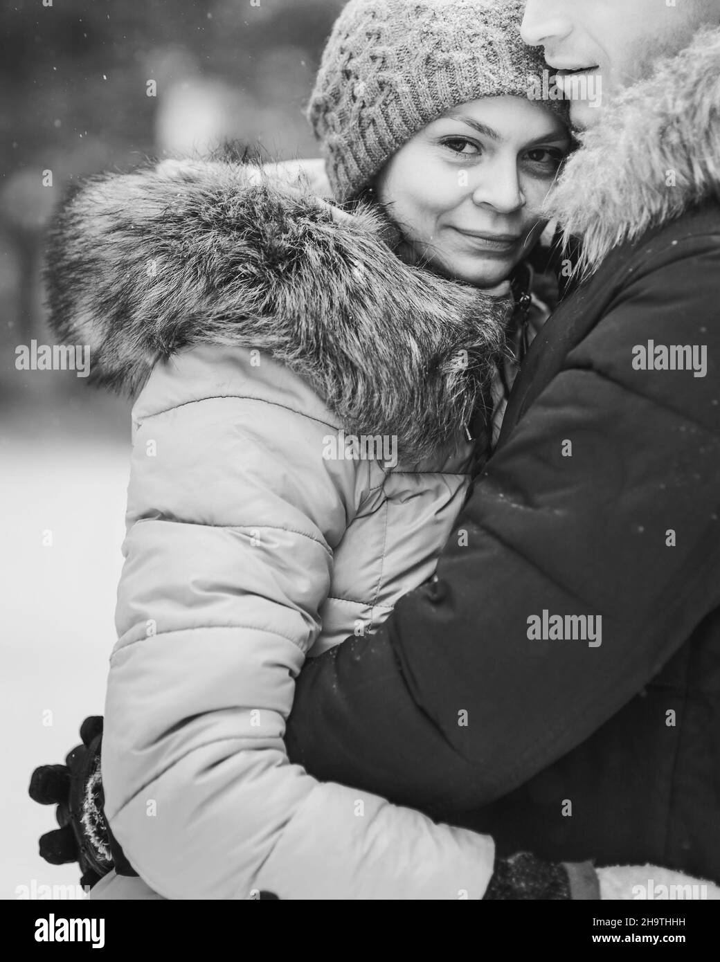 Ritratto di giovane coppia nella foresta invernale. Bianco e nero Foto Stock