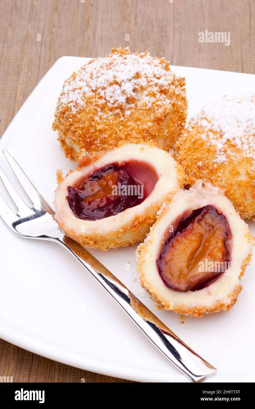 Gnocchi di prugne, prugne, Austria, tipici, dolci, dessert, pasticceria, briciole, zucchero a velo, frutta, piatto, tavolo, bianco, legno, tavolo in legno, forcella, cagliata, riempimento Foto Stock