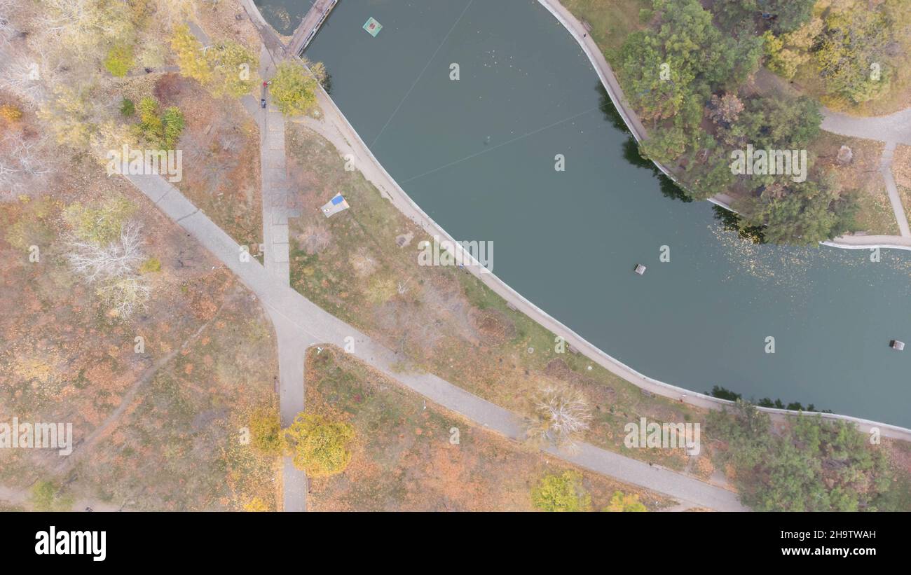 Sentieri e sentieri nel parco della città in autunno. Foglie caduta nel parco. Lago d'autunno. Vista aerea Foto Stock