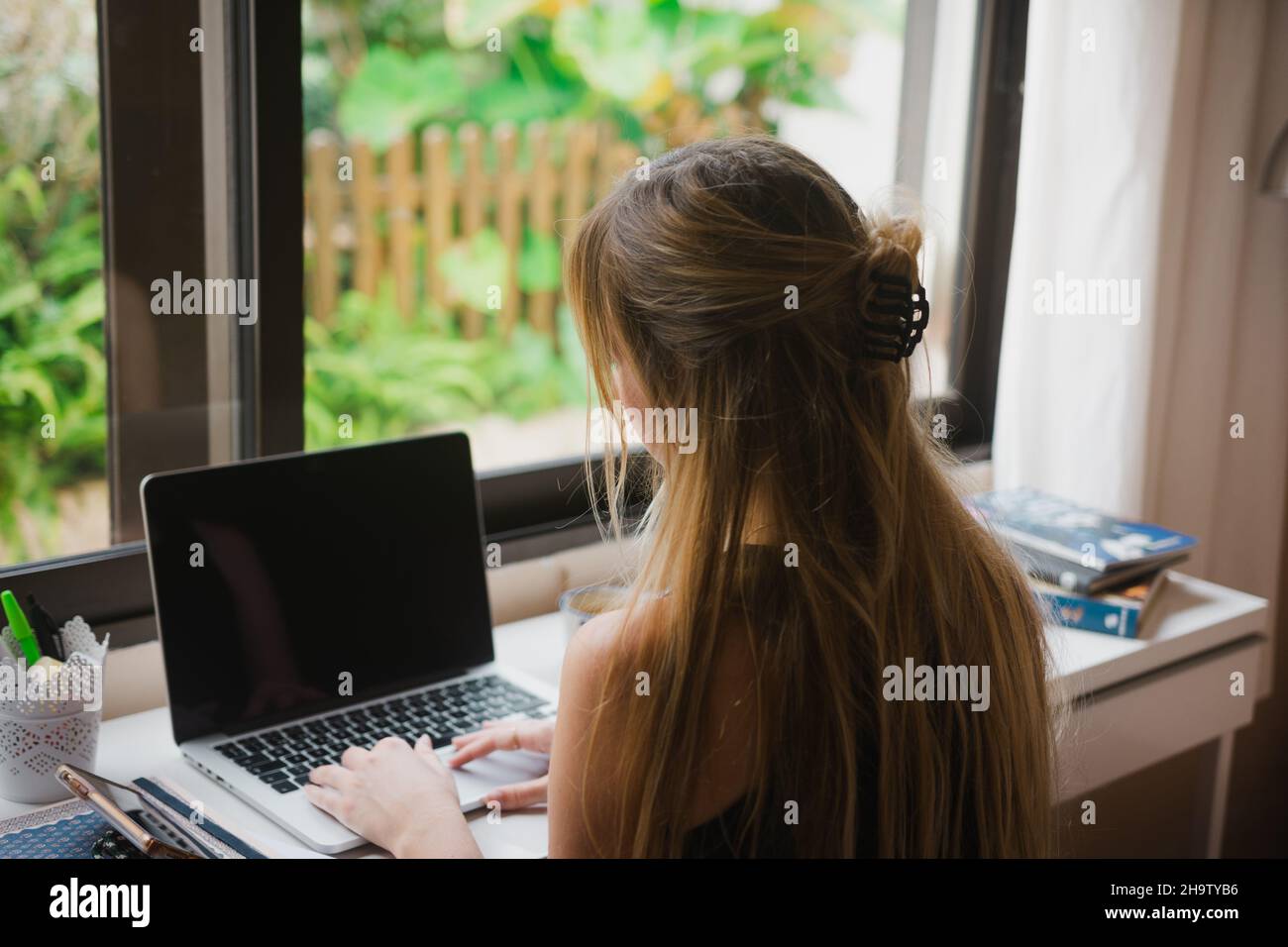 Giovane donna che digita su un portatile. Foto Stock