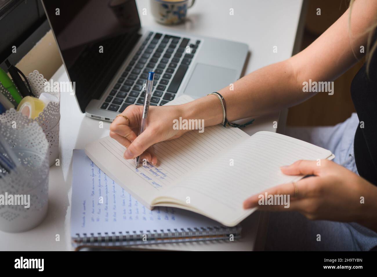 mani di una donna che scrive su un notebook. Foto Stock