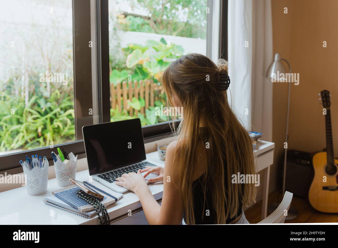 Giovane donna che digita su un portatile. Foto Stock