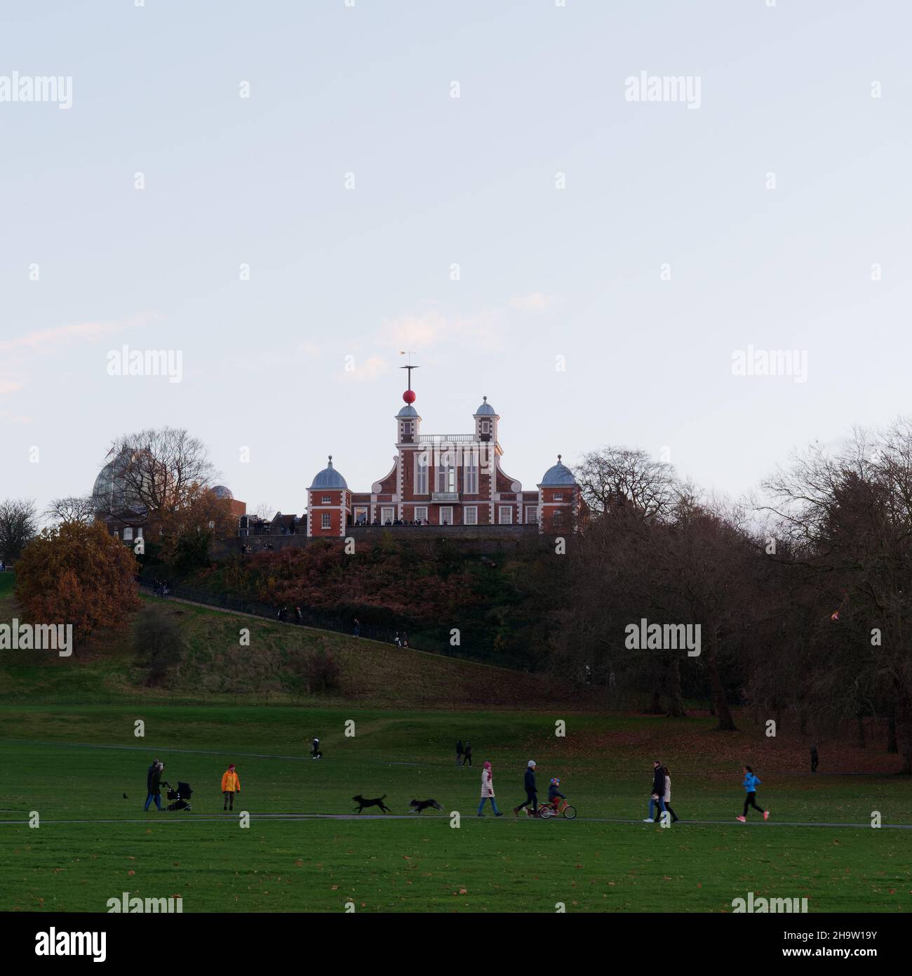 Londra, Greater London, Inghilterra, dicembre 04 2021: Famiglie che camminano a Greenwich Park con il Royal Observatory sulla collina alle spalle. Foto Stock