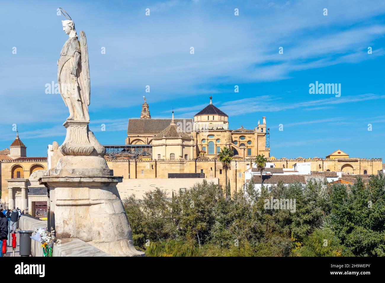 La statua di Archangel Raffaello sull'antico Ponte Romano con il castello e la città di Cordoba Spagna in vista. Foto Stock