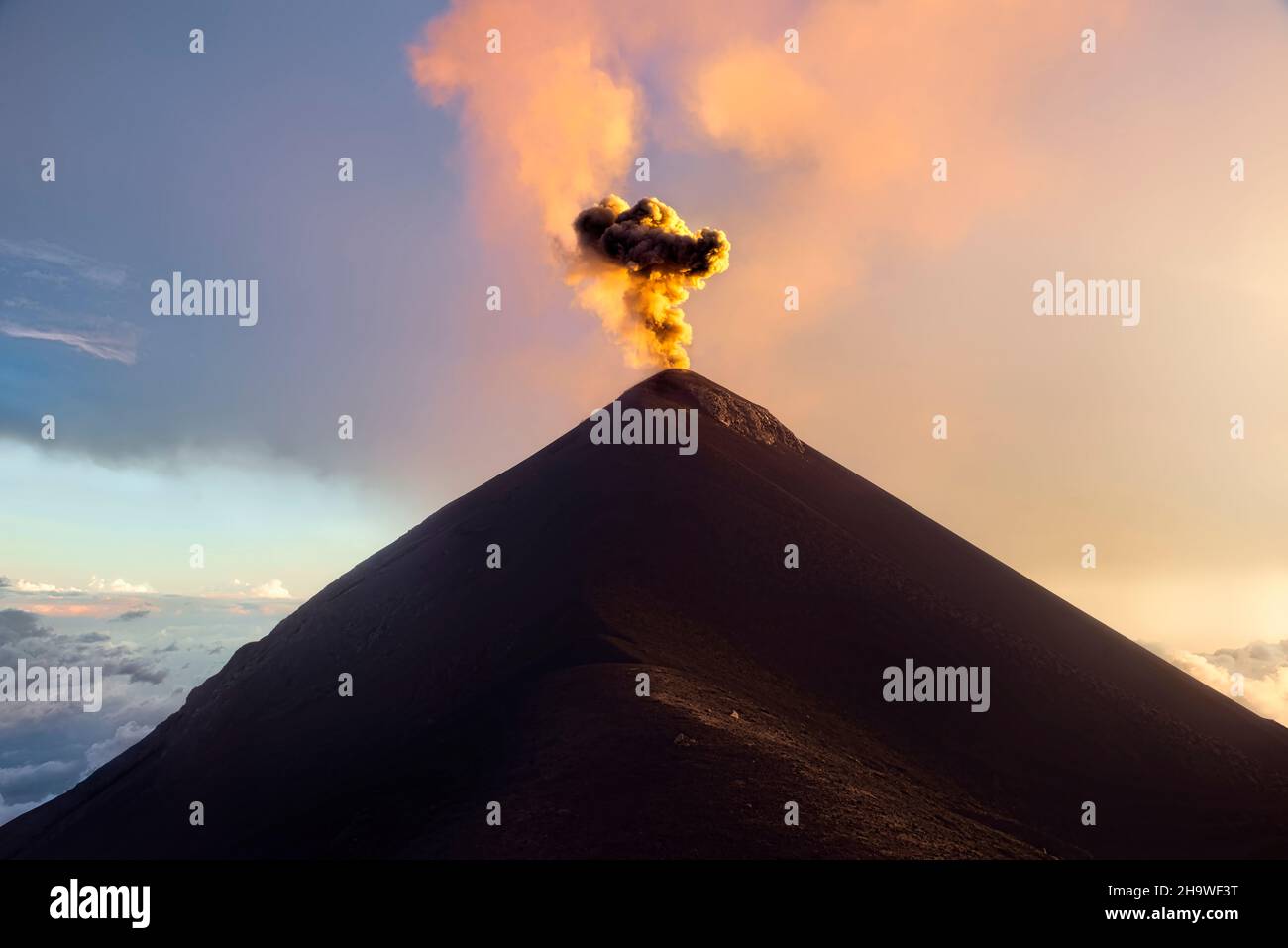 Vulcano Fuego che erutta al tramonto, Antigua, Guatemala Foto Stock