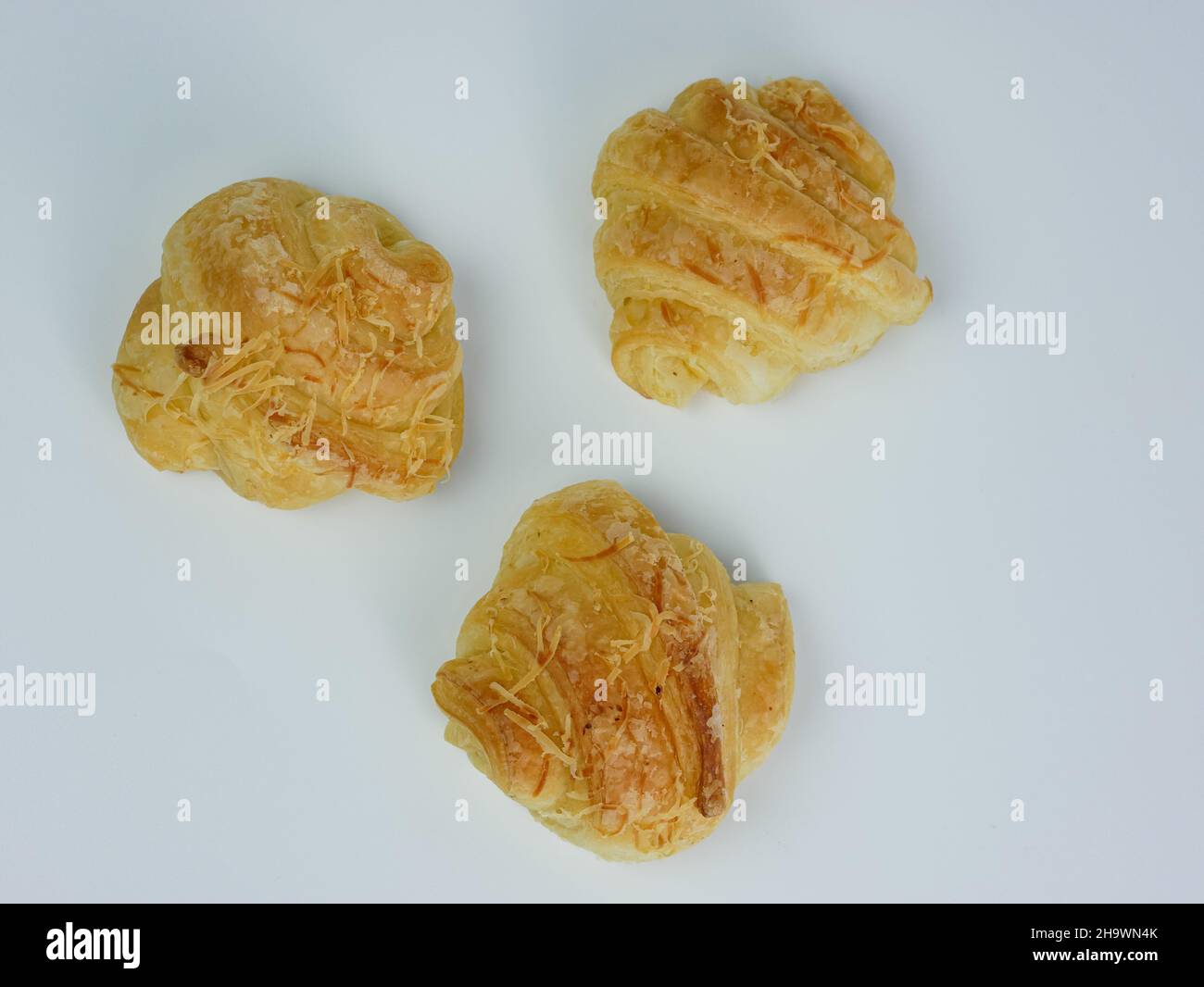 vista dall'alto di tre croissant al formaggio su sfondo bianco Foto Stock